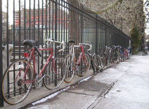 Bikes parked at a fence in NYC. Photo by Jym Dyer